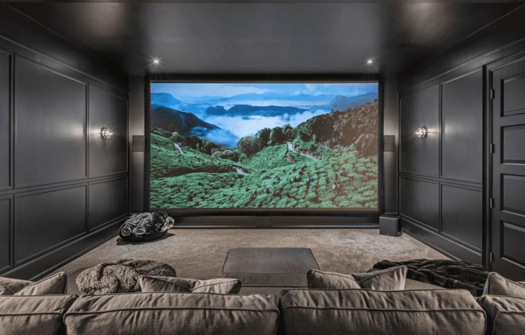 Theater room with projector, screen, and sound system.